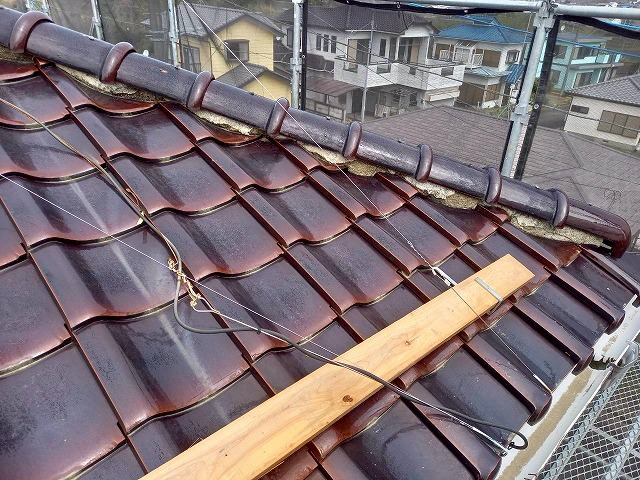 強風時に瓦が落下した住宅屋根の棟部漆喰が剥がれ落ちている様子