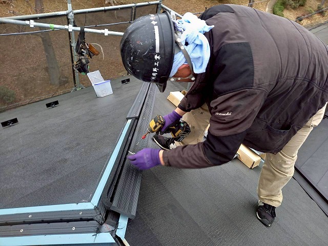 住宅屋根カバー工事で隅棟部へ樹脂製下地材をビス固定している様子
