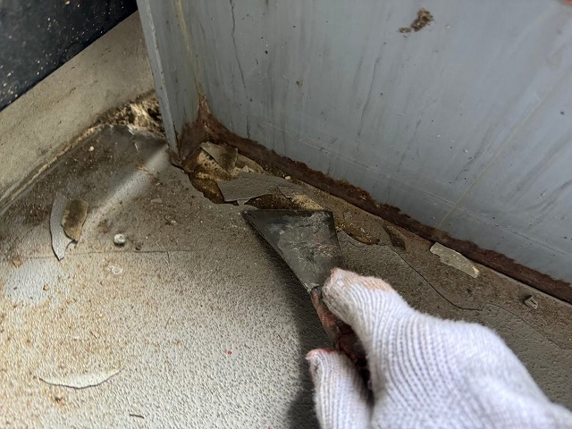 ヘラを使って劣化で傷んだ塗膜を削り落としている状況