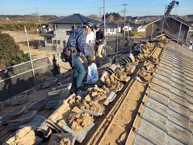 屋根葺き替え工事で棟部の土や漆喰を解体している様子