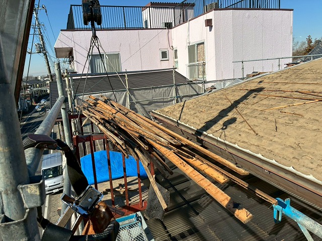 屋根葺き直し工事で解体を終えた瓦桟をユニック車で降ろして処分