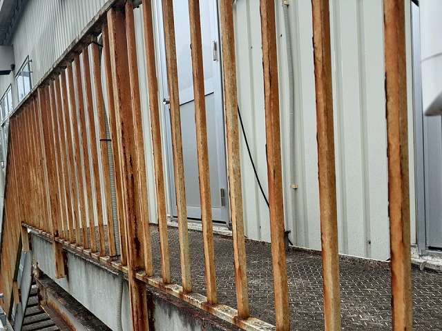 工場建物の鉄骨階段の手すり支柱にサビが進行した状態