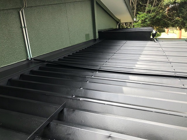 3回塗りが完了しツヤのある仕上がりとなった黒い金属屋根