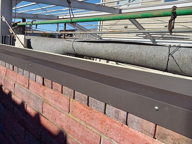 カーポート波板張り替え工事でレンガ塀の天端に水切り板金をビス固定