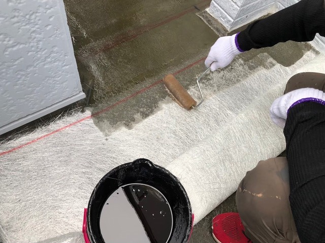 FRP防水メンテナンスでガラス繊維マットにポリエステル樹脂を塗布している様子