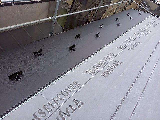 屋根カバー工事で軒先の金属屋根本体葺きと雪止め金具の取り付けが完了