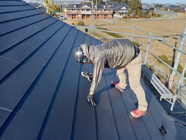 屋根カバー工法リフォームの金属屋根に葺き掃除を行っている状況