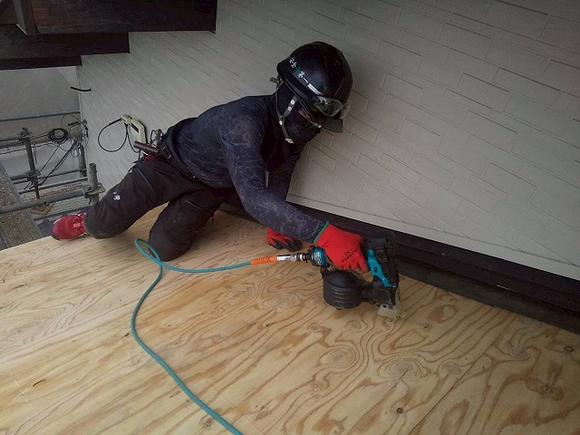 屋根葺き替え工事の野地板増し張り工程で下屋根部の構造用合板釘留め