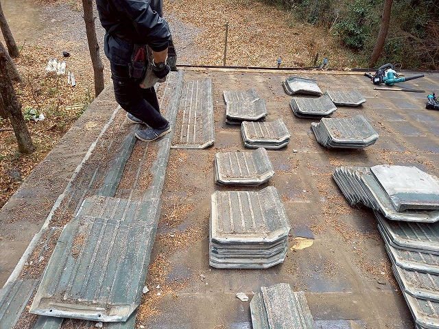 別荘建物屋根葺き替え工事で既存の劣化したセメント瓦を解体している様子