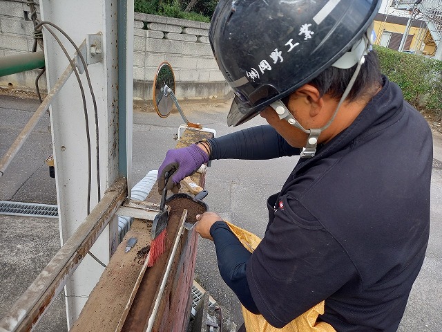 レンガ塀の天端に設置されている水切り板金の下地清掃
