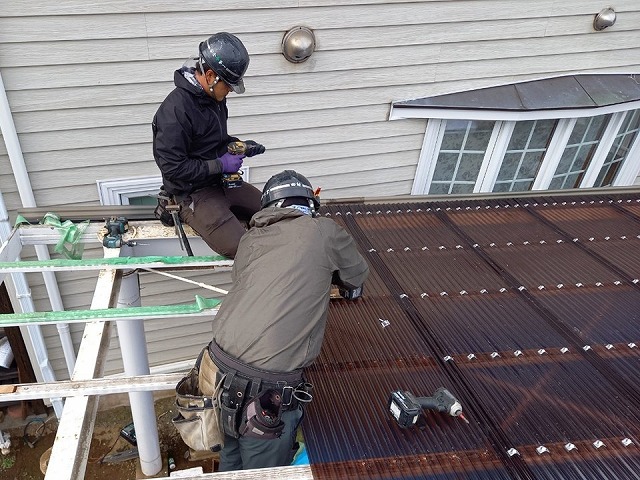 住宅カーポートポリカ波板張り替え工事で波板を鉄骨下地に留め付けている職人