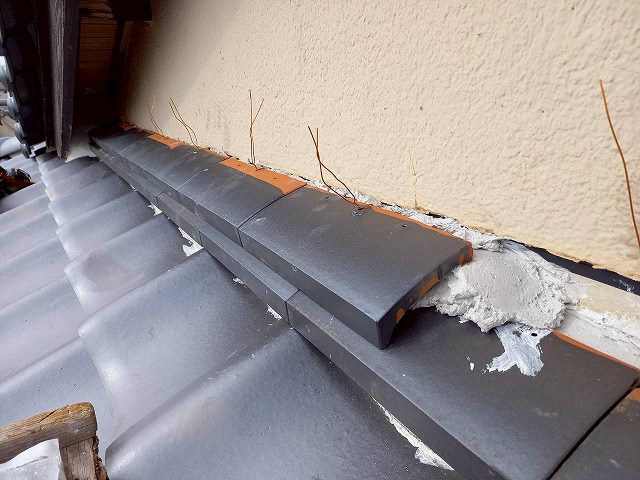 屋根葺き替え工事の下屋根と外壁との取り合い部への2段目のし瓦銅線固定