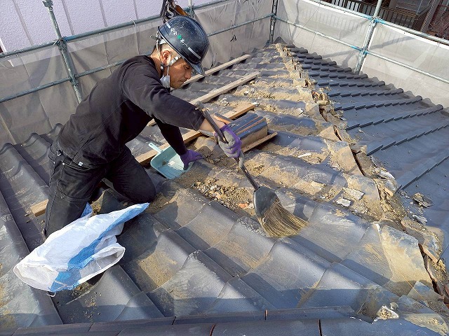屋根葺き直し工事で棟瓦解体後に清掃を行っている様子