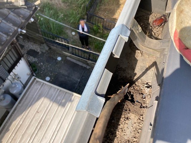 木の棒で雨どいの穴を貫通させます