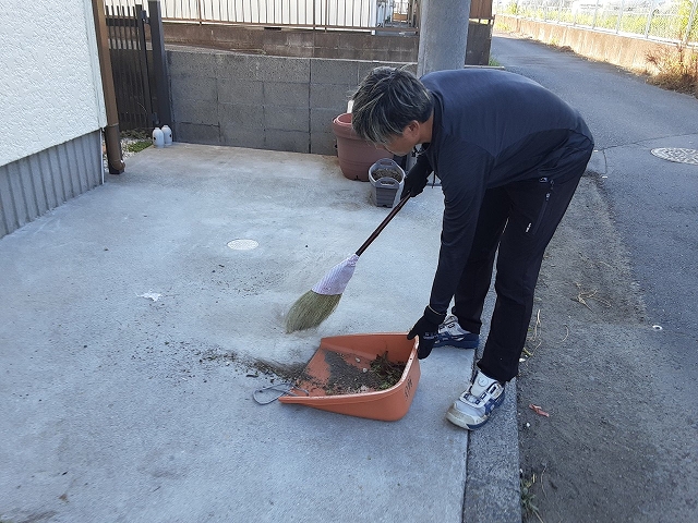 ちり取りゴミを取るスタッフ