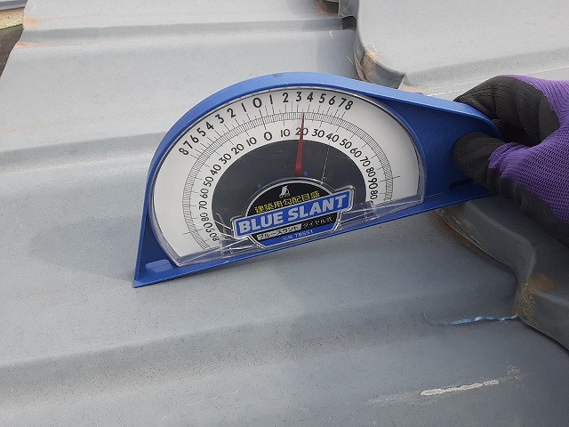 屋根に勾配計をあてる