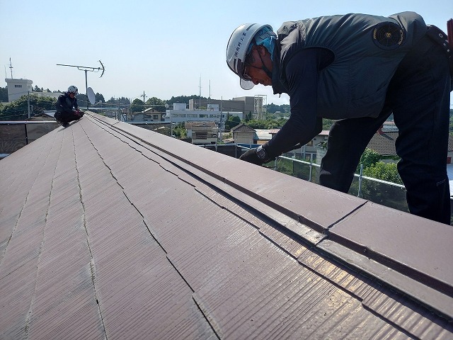 棟板金を外すスタッフ