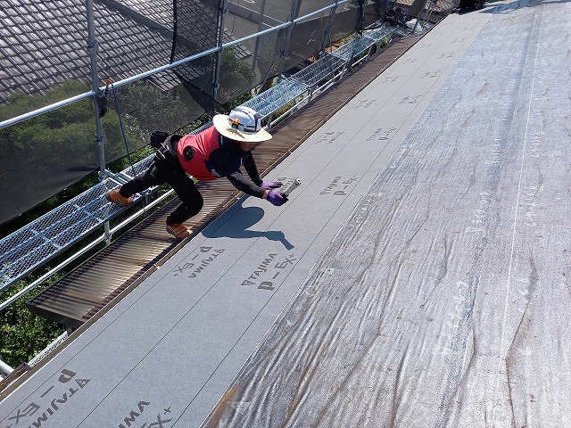 防水シートを貼るスタッフ