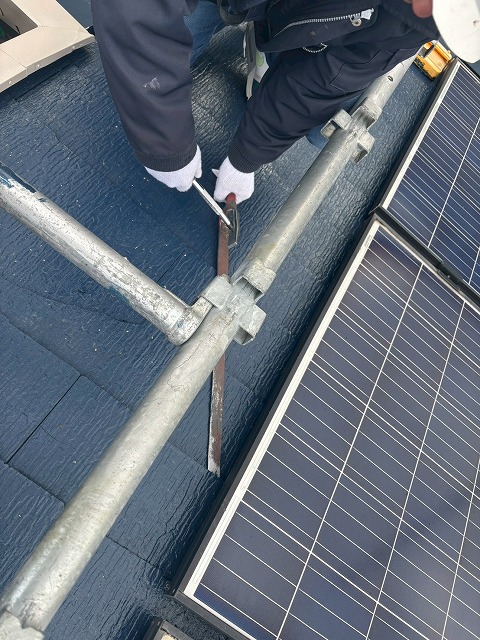 気仙沼市で割れたスレート瓦の釘を抜いている様子