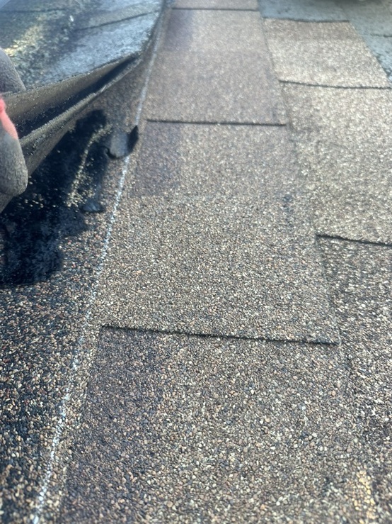 新しいアスファルトシングルを差し込みます。 釘と接着剤で固定します。