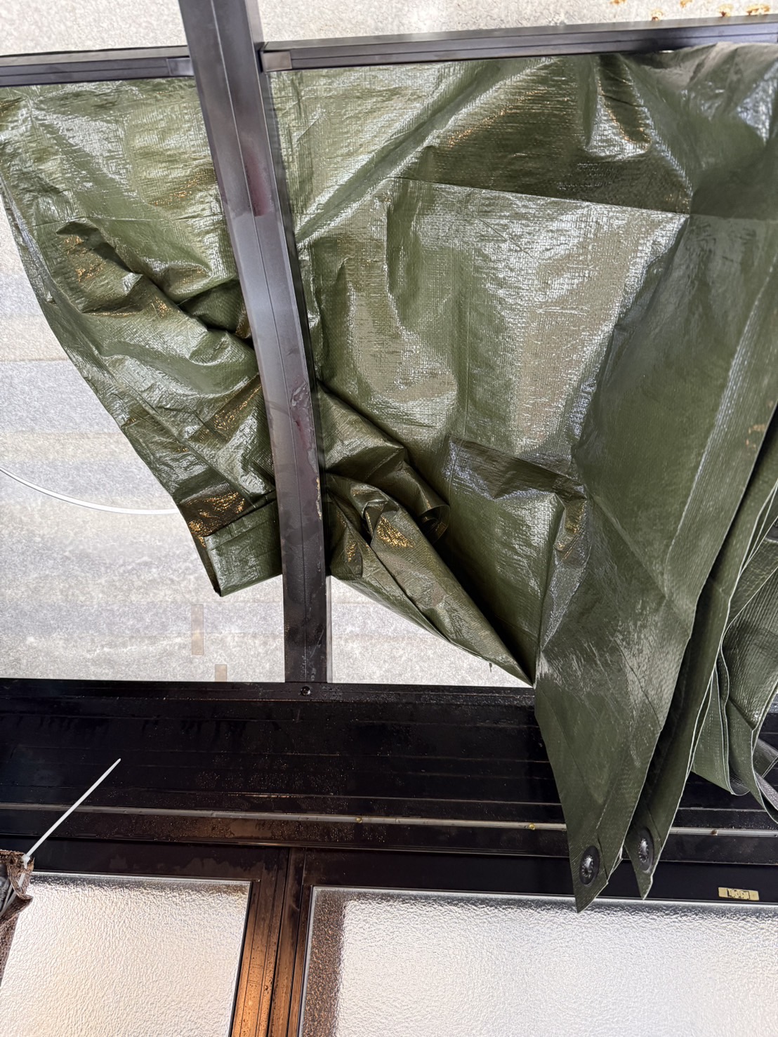 現地を見ると、お客様ご自身で、 割れてしまった屋根パネル部分にシートを使った養生をされていました。  雨や雪が入り込まないように、 できる範囲でしっかり対応されていた様子が分かります。