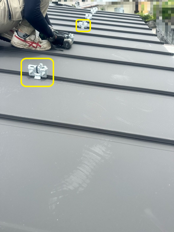 立平葺き屋根の凸部分に、雪止めアングルの金具を挟んでナットで締めています。