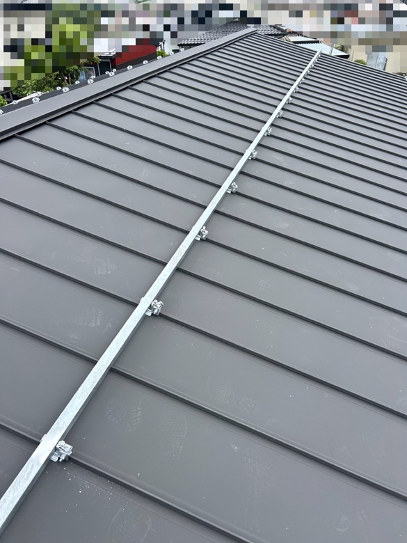 屋根の凸に設置していた雪止めアングルの金具に、雪止めアングル（スチール製の棒）を横一直線に乗せて、金具で挟み込んでナットで締めて固定しています！