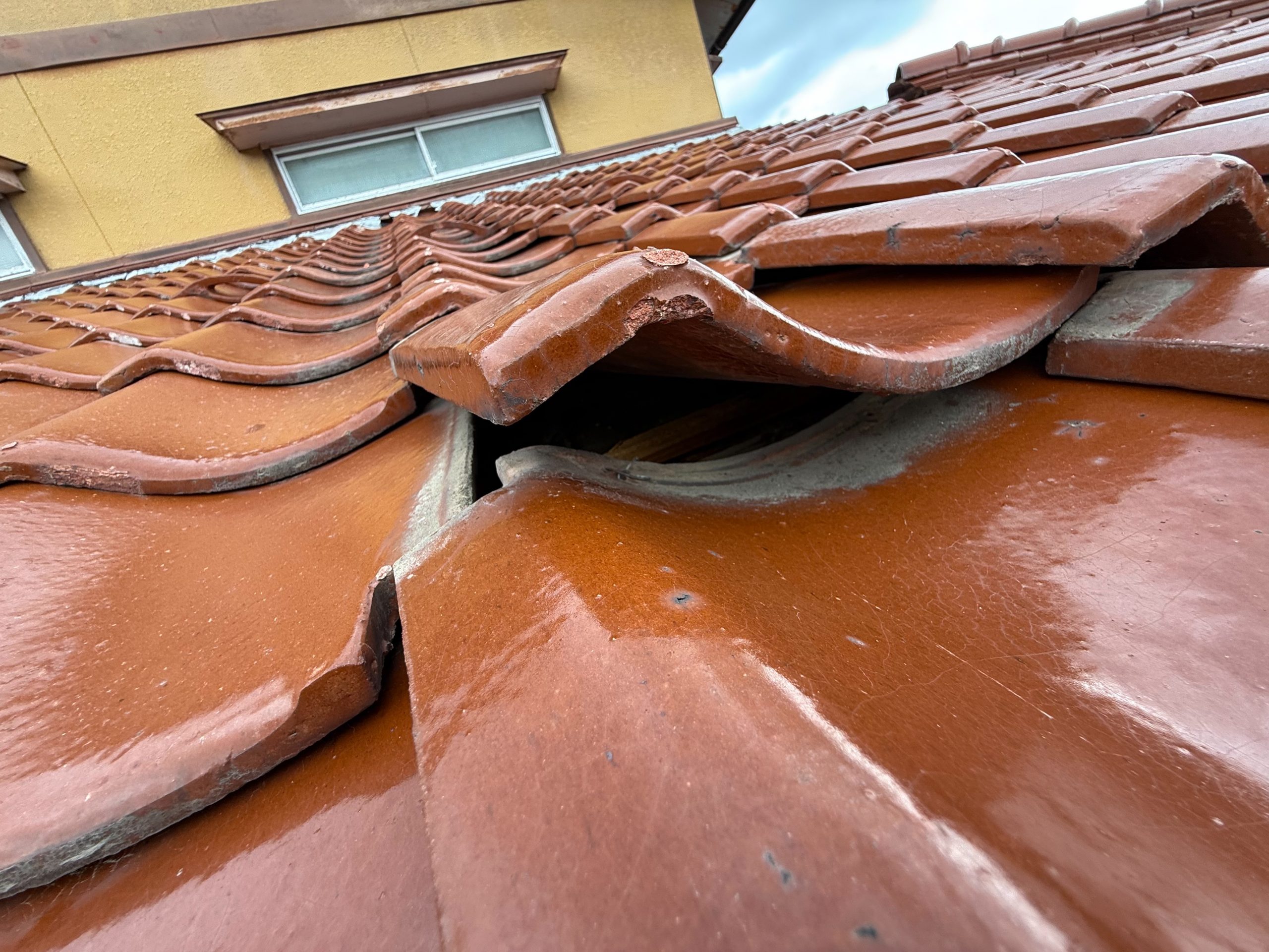 玄関の上の瓦がずれています