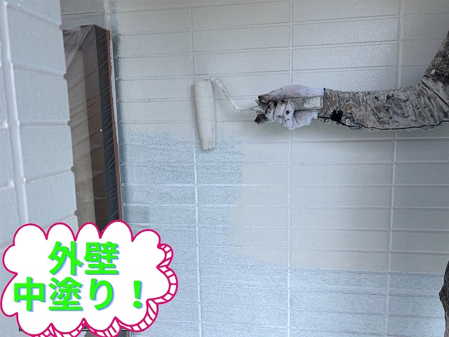 外壁に中塗りをしている職人の様子。グレー系の塗料で均一に仕上げている。