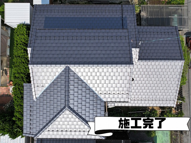 ドローンから撮影した葺き替え後の屋根全景。栄四郎瓦プラウドUU40Gが均一に美しく並び、棟や谷板金も新しく整った状態が一目でわかる完成写真。