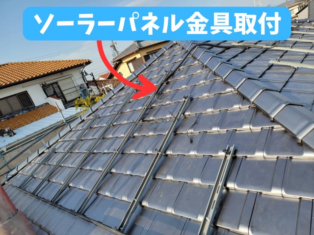 ソーラーパネルを再び屋根に設置している様子。金具の固定中