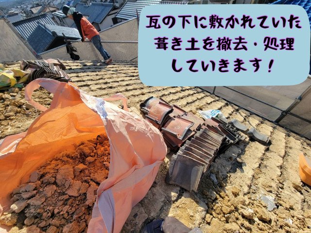 屋根上に積もった葺き土をオレンジの袋に集めている様子