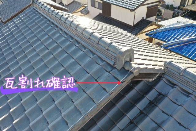 屋根の端部で瓦が割れている箇所のクローズアップ。表面のひび割れと欠けが見られる