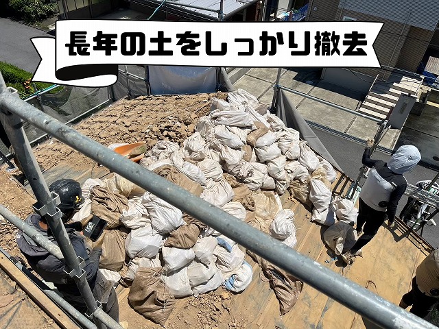撤去した大量の土を袋詰めし、屋根から下ろしている様子