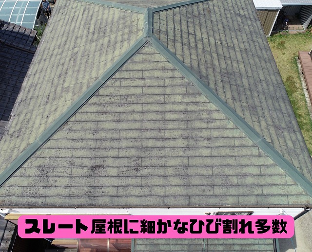 近距離のドローン写真。スレート屋根に細かなひび割れや退色が多数見られる状態。