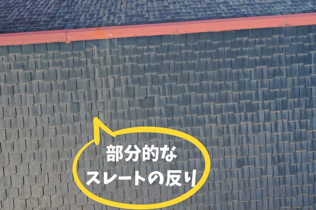 部分的に反りが発生しているスレート屋根を拡大撮影した写真。