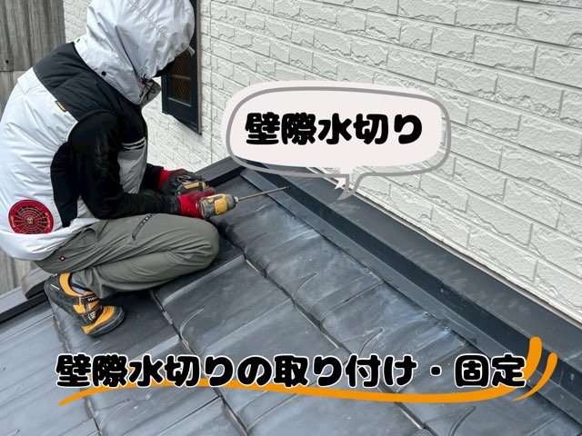 作業員が壁際に黒い新しい水切り板金を取り付けているところ。瓦との取り合いがきれいに整っている。