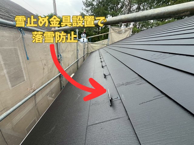 ガルバリウム鋼板屋根の上に雪止め金具を一定間隔で設置し、落雪防止対策をしている様子