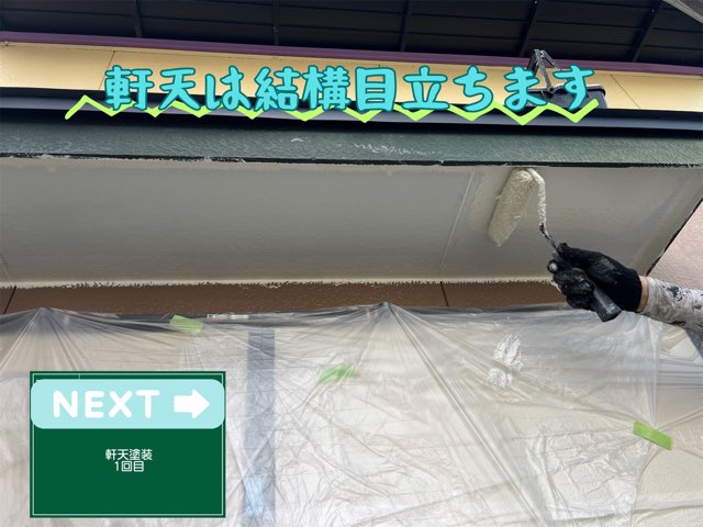 軒天に白い塗料をローラーで塗っている様子（1回目）。