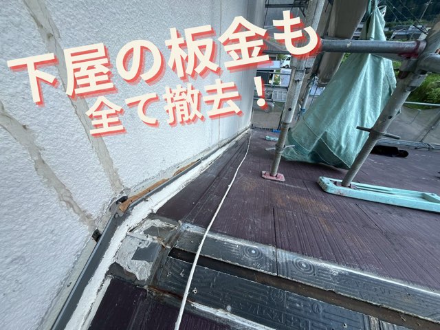 屋根と壁の取り合い部の様子。古いシーリングや板金の補修跡が見える。