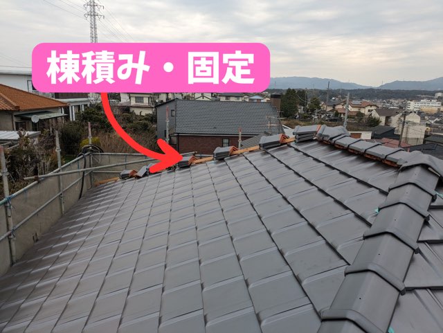 棟部分に新しい芯木を設置している様子。周囲に瓦が積まれている