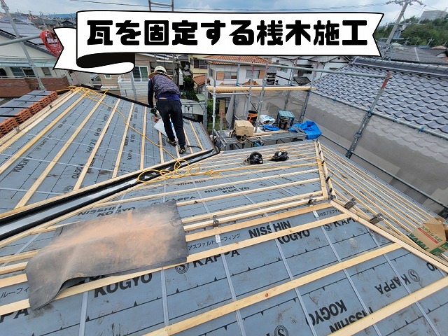瓦を引っ掛けるための桟木を丁寧に取り付けている様子