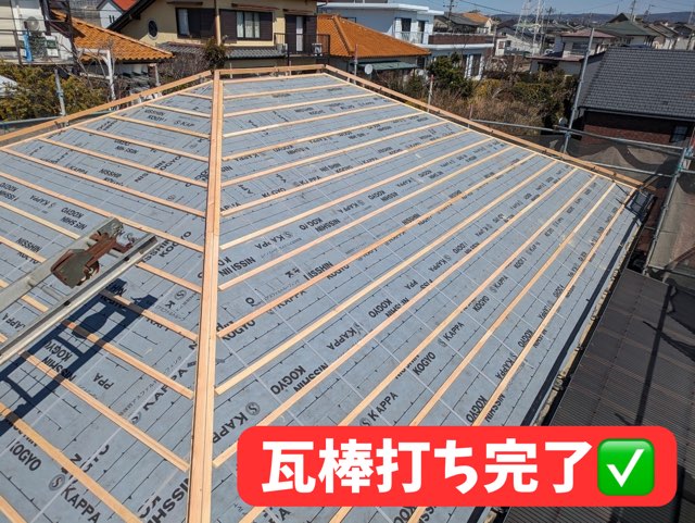 瓦棒を設置した屋根上。整然と並んだ木材が見える
