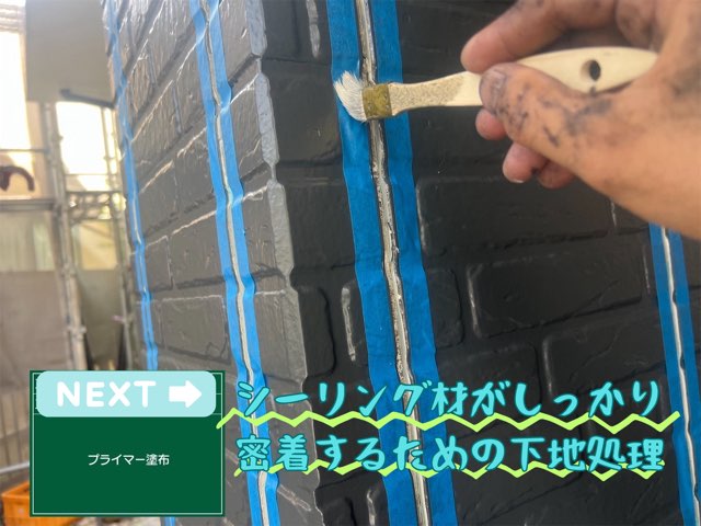 刷毛で外壁の目地にプライマーを塗布している職人の手元