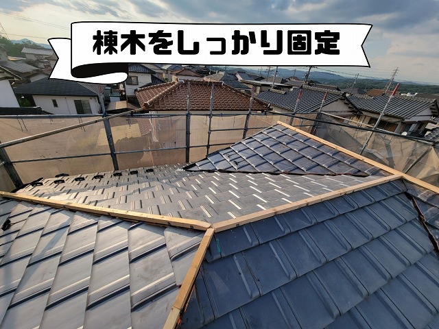 屋根の頂点に棟木をまっすぐ固定している様子