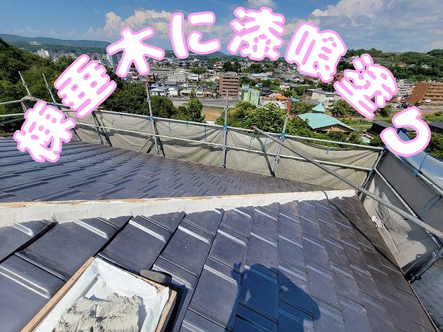 棟木部分に漆喰を塗り込んでいる作業風景