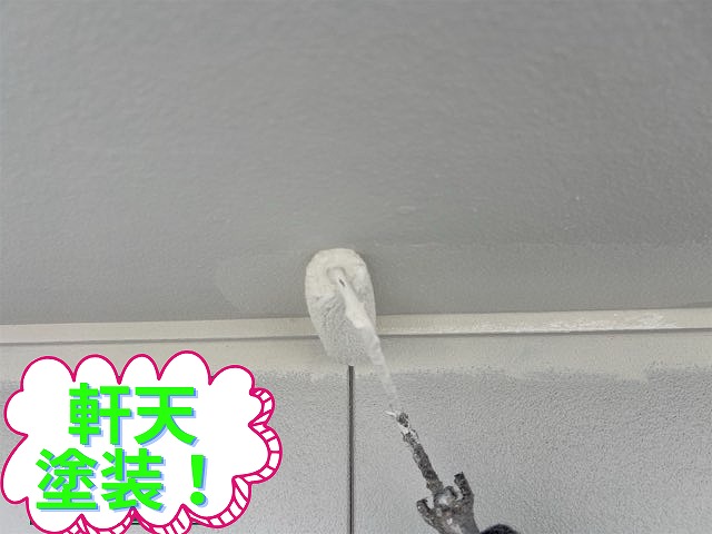 軒天塗装中の写真。白い塗料をローラーで塗っている。