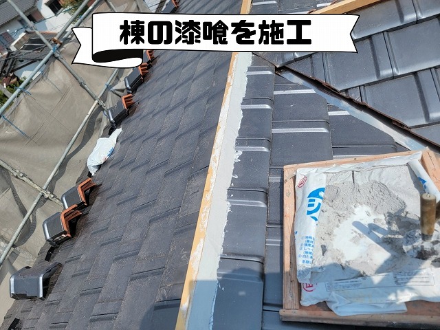 棟部分に新しい漆喰を塗り込んでいる作業の様子