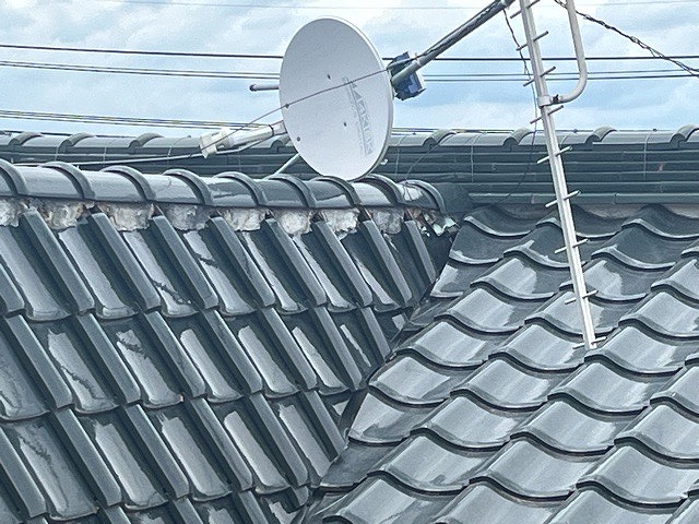 緑の和瓦 棟周辺にアンテナが倒れている