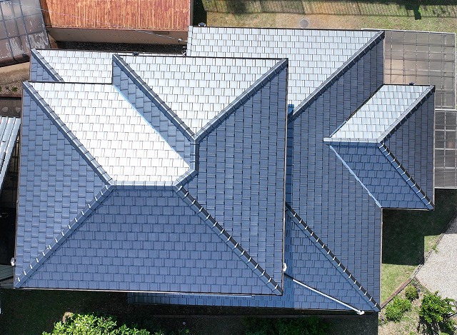 多治見市京町にて実施した母屋の葺き替え工事完了後のドローン撮影写真。新しい瓦が整然と並び、美しい青みのある屋根が輝く仕上がりになっています。離れ棟の積み替えと軒天塗装も完了し、全体が統一感のある外観に生まれ変わりました